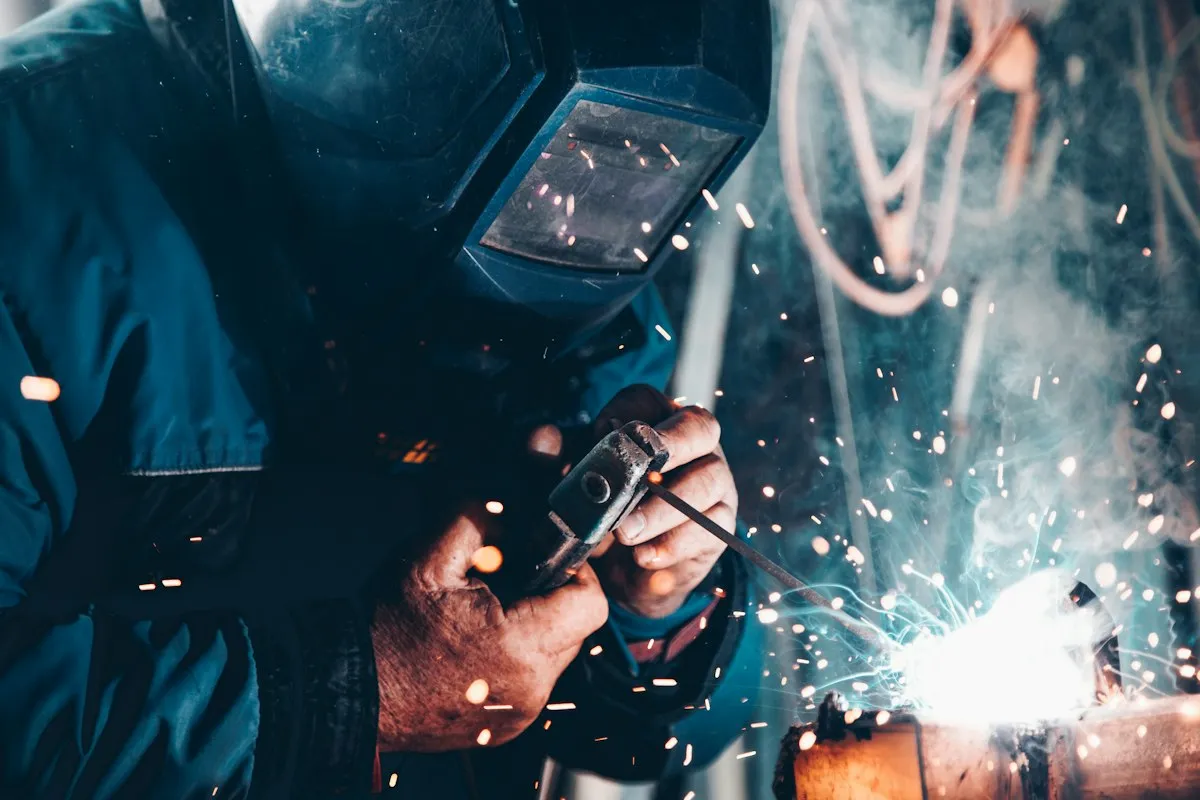 Welder working on industrial equipment during installation