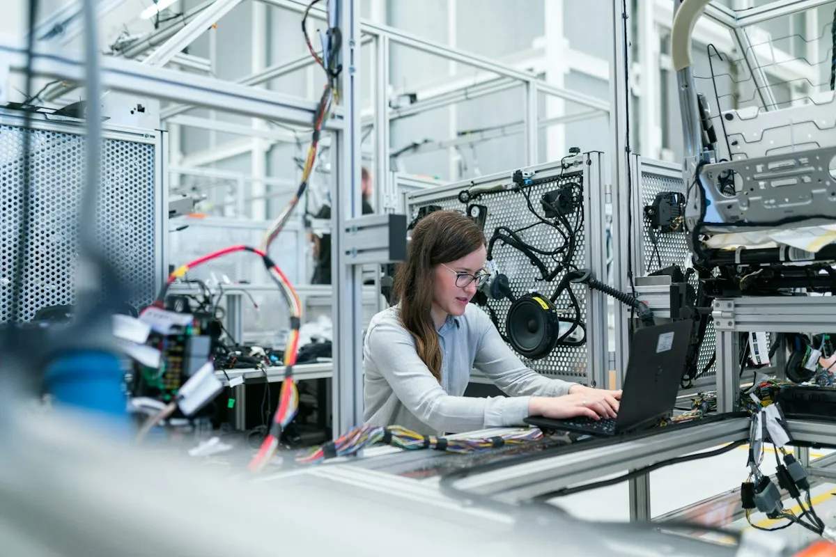 Engineer programming industrial automation equipment on a laptop